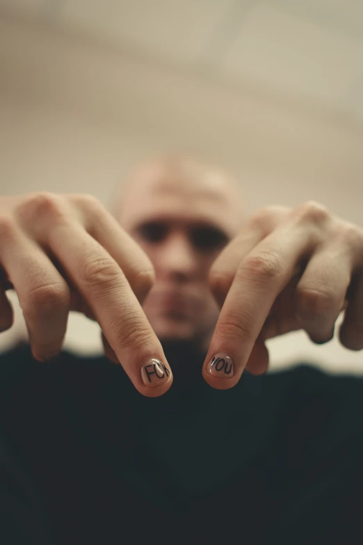 a man holding his fingers with a smiley face on it