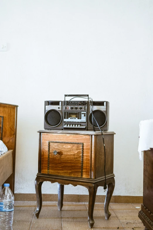an old radio sits on top of a nightstand next to a bed