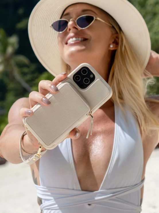 a blonde woman with glasses, a hat, and a cell phone