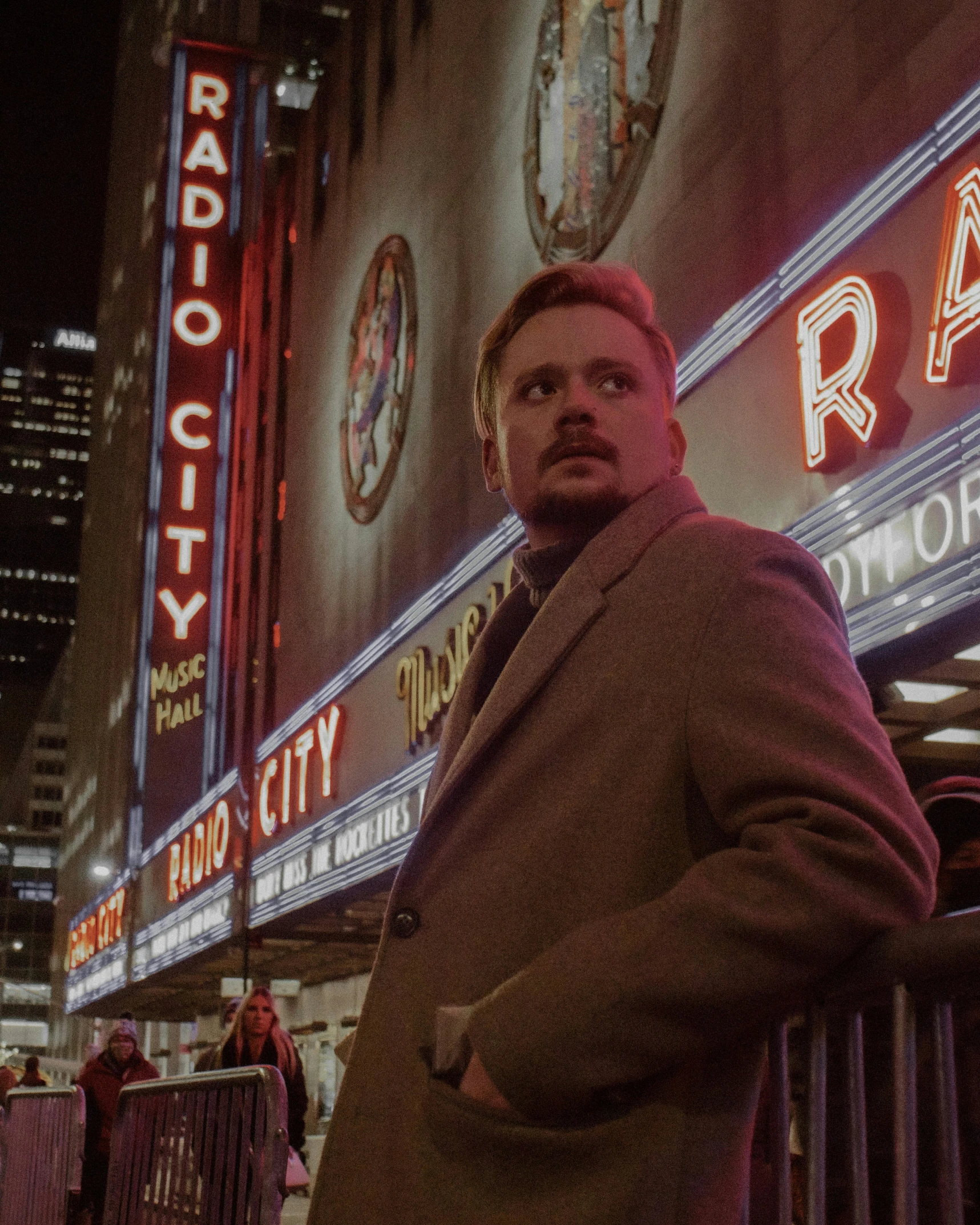 a man standing in front of a theater marquee