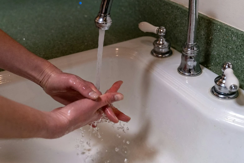 someone is washing their hands in the sink