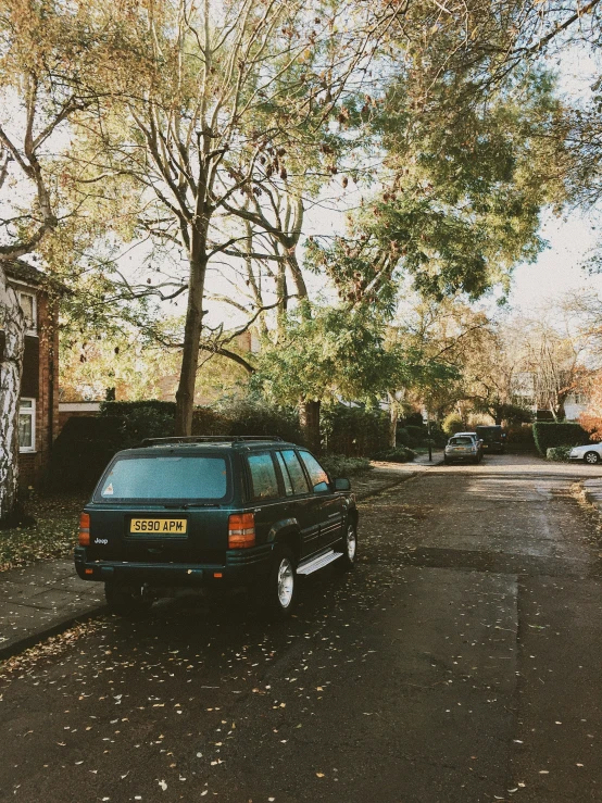 an old fashioned car parked on the side of a road