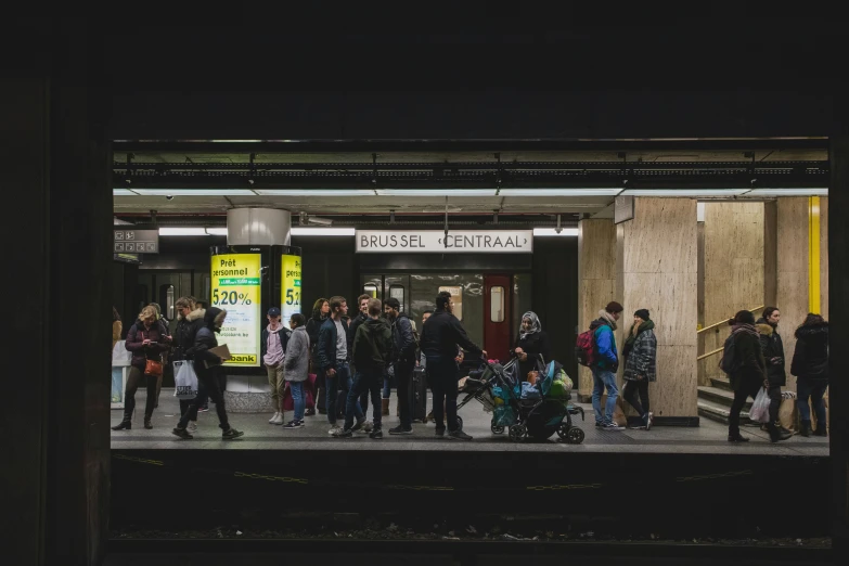 a group of people stand in line at the station