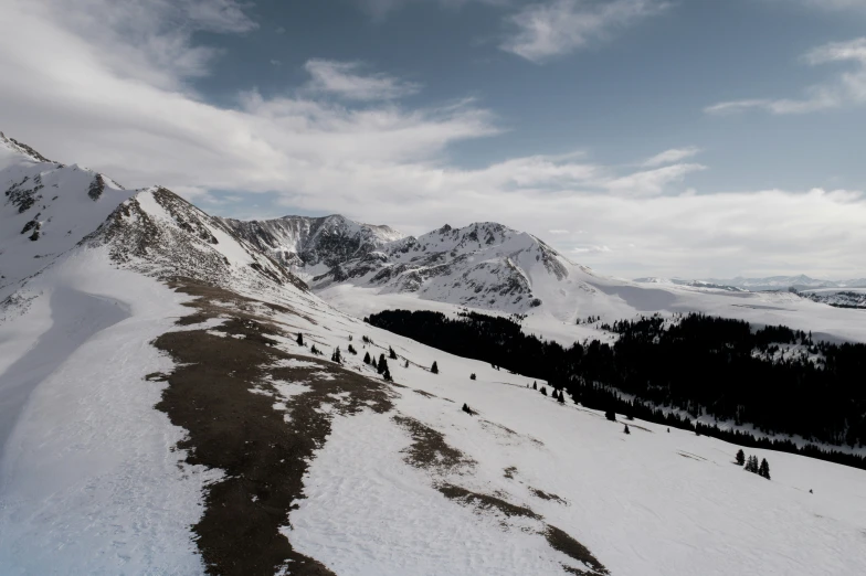 people stand at the base of a mountain ridge