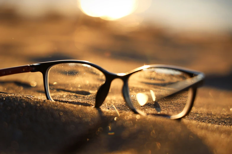 glasses sitting on a table with the sun reflected on them
