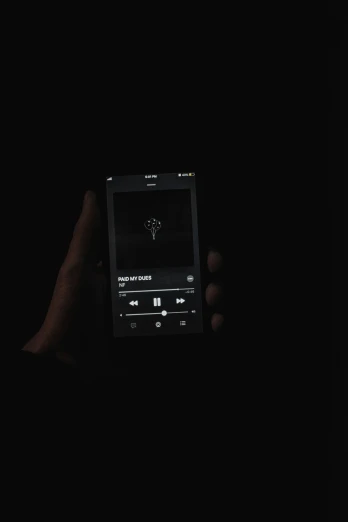 a person holding up a smart device in the dark