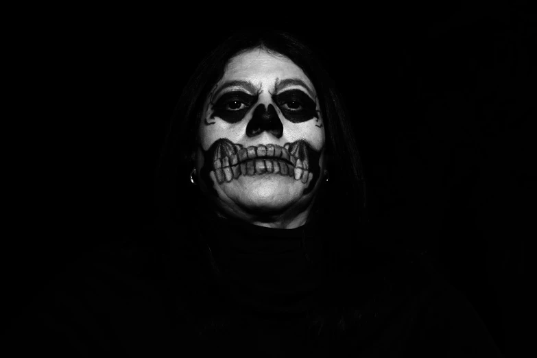 a woman with a painted skull face in the dark