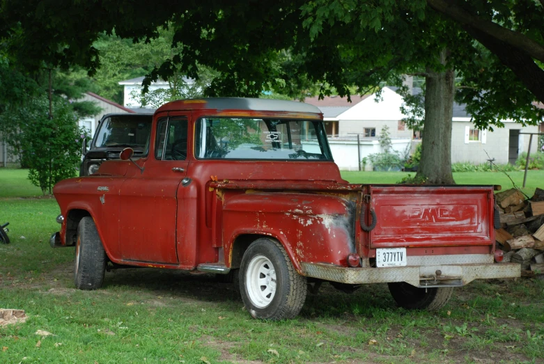 an old truck has been parked next to a tree