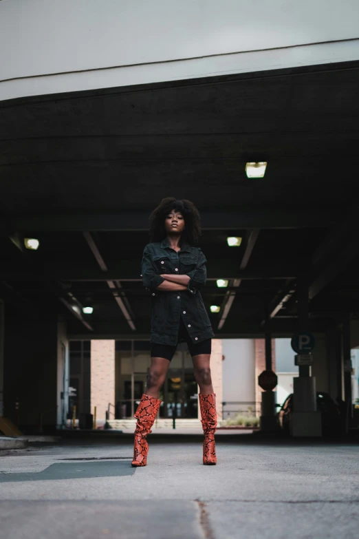 a woman wearing boots is posing in an empty building