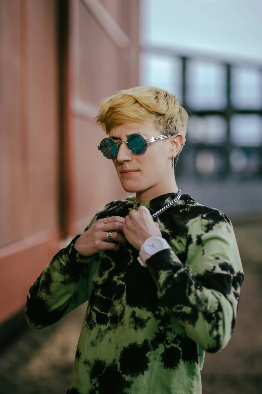 a young blonde female is wearing sunglasses and a green top