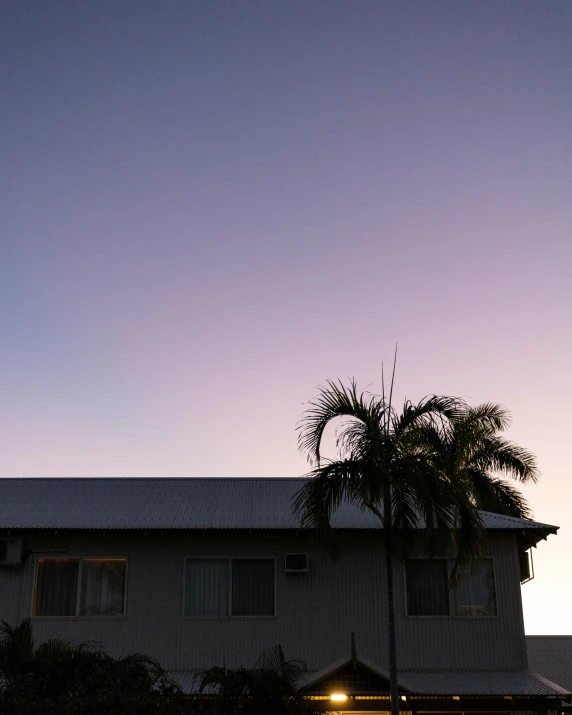 the top of a roof and building is lit up at dusk