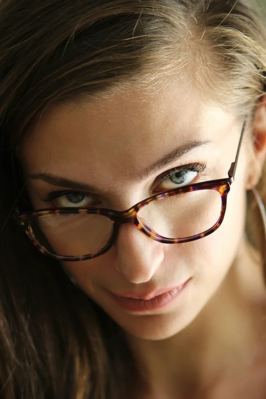 a woman is wearing glasses posing for the camera