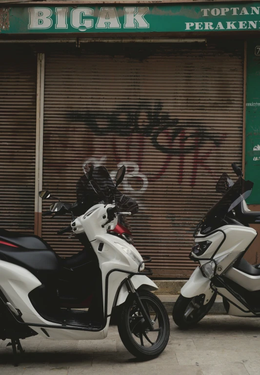 two motorcycles parked next to each other in front of a building