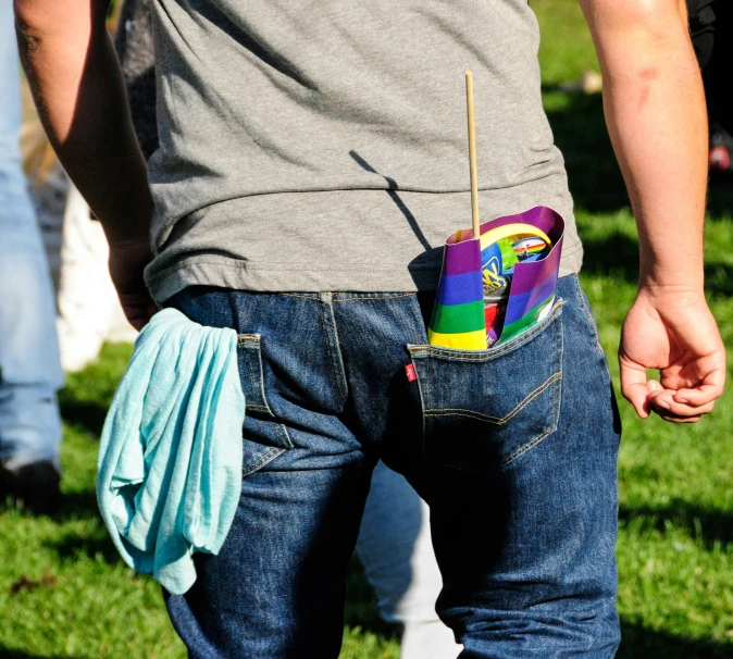 a colorful container in the back pocket of a person