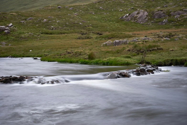 an alpine river flowing across the mountain side