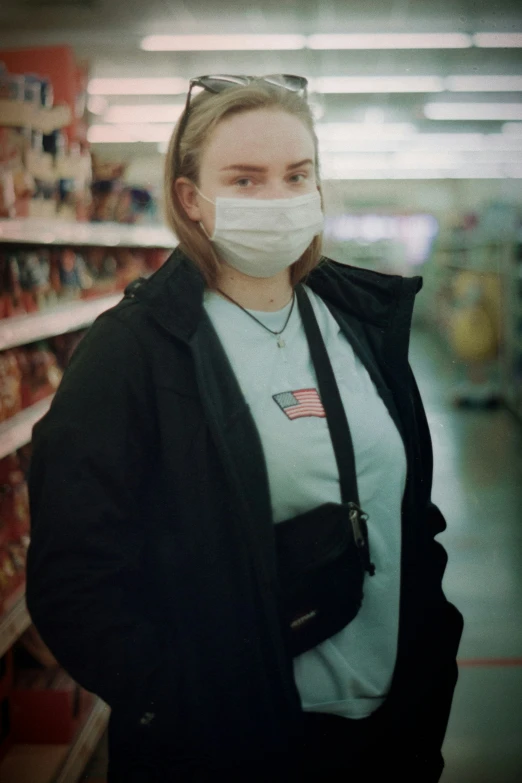 woman with surgical mask standing in a supermarket aisle