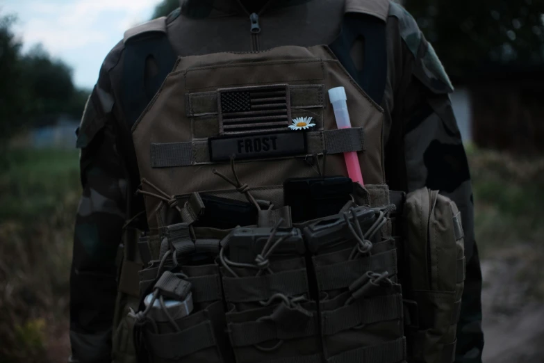 a man wearing a floss utility vest that has a bullet in it