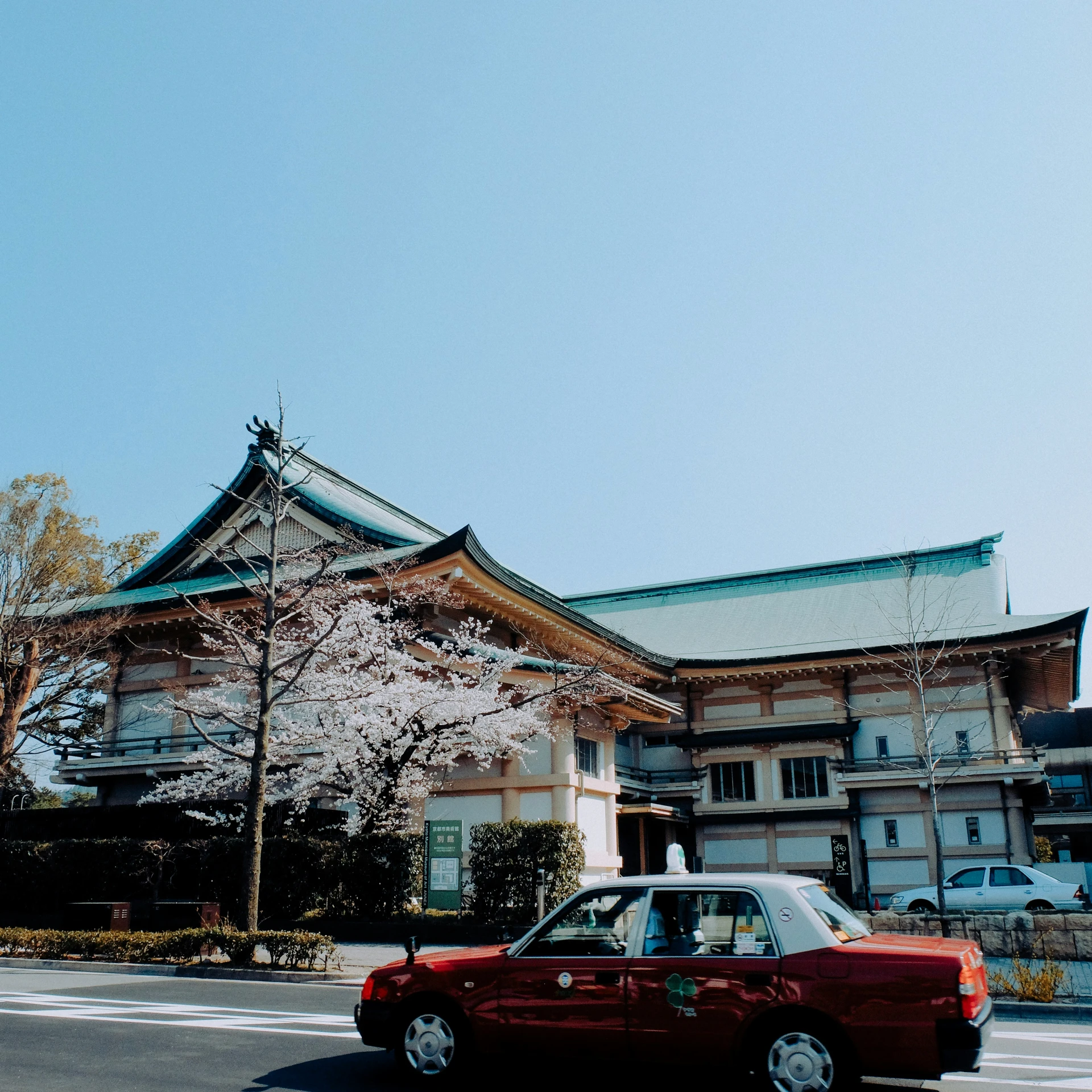 a red car is parked in front of an old building