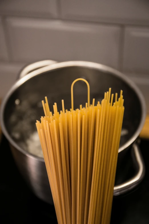 a pasta noodle is being held in a bowl