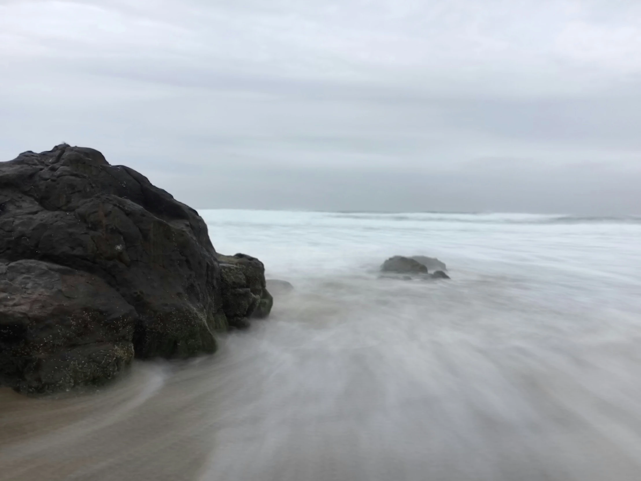 the shore of a beach that has rocks in it