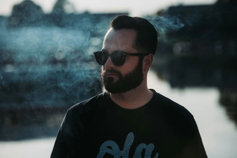 a man wearing a tshirt, smoke and sunglasses