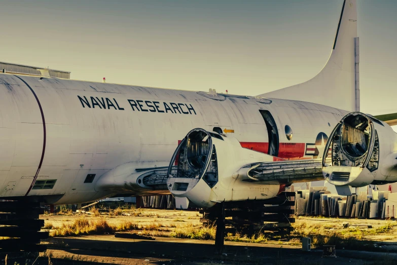 an airplane sitting in an old junkyard with its door open