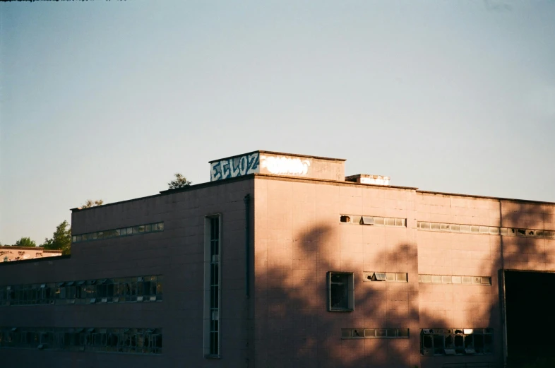 an orange building with large windows and trees