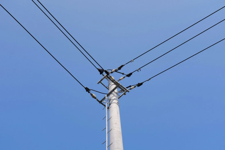 some power lines with wires on them against a clear blue sky