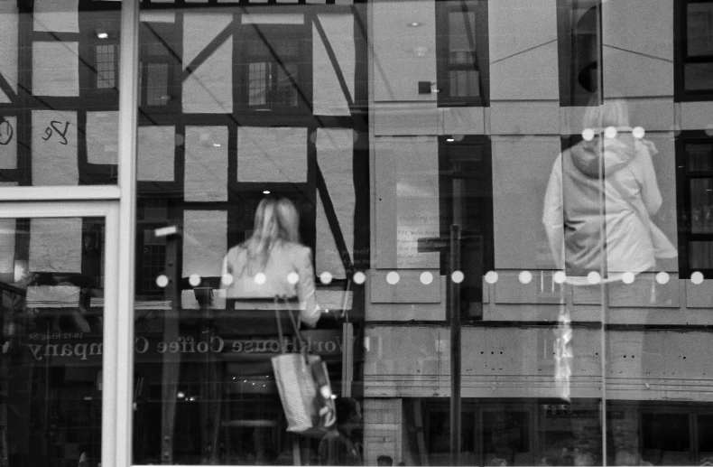 a girl is outside of the building looking in the window