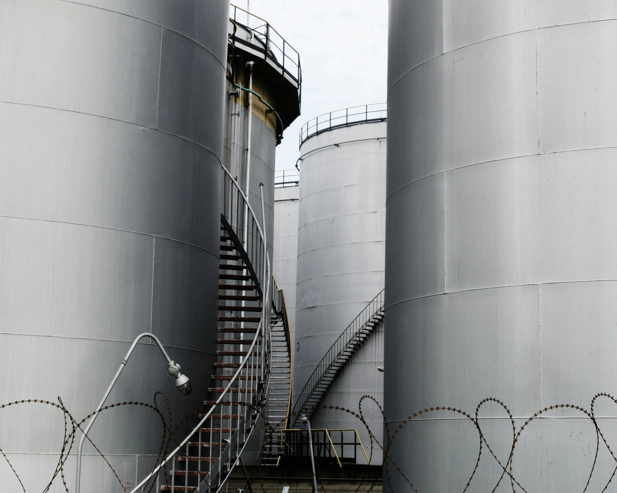 several large grey tanks with handrails next to each other