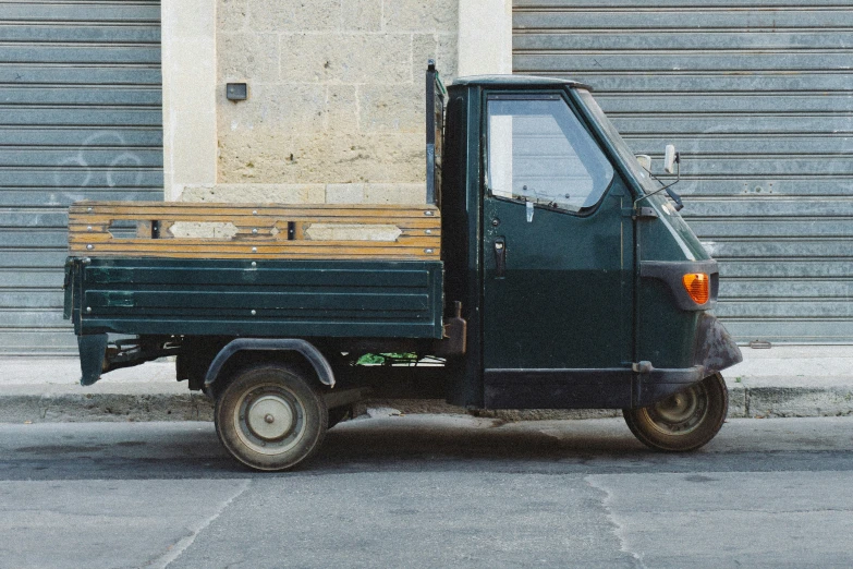 a small truck parked by the side of a building