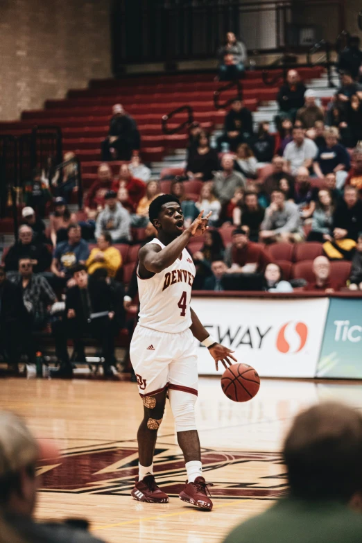 basketball player on court with ball and crowd in background