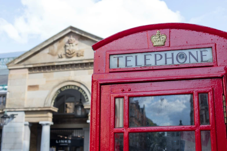 an old style phone booth is shown in front of a building