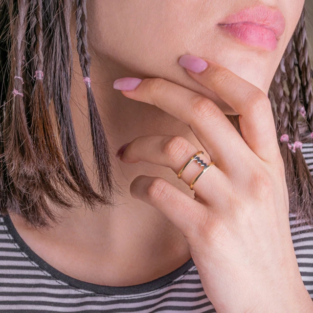 a close up s of a woman with pinkish nails and ring