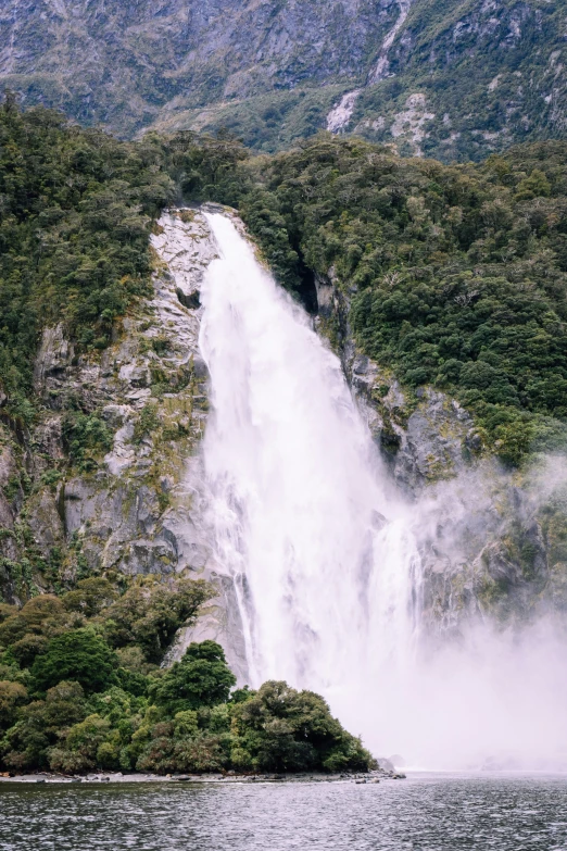 the boat floats close to the huge waterfall