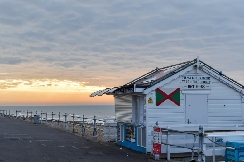 the white building sits next to the ocean with people standing around