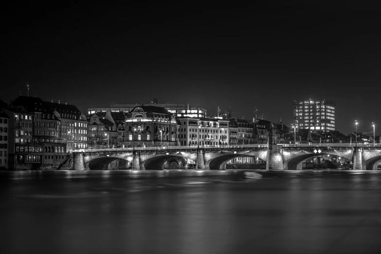 an urban bridge over the water and a night view of a city