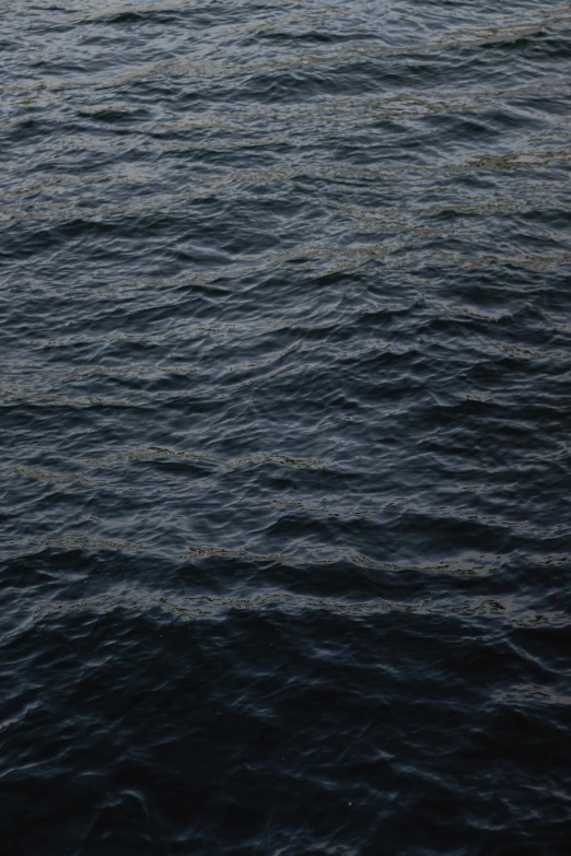 a dark blue ocean with water marks, some lines in the sand