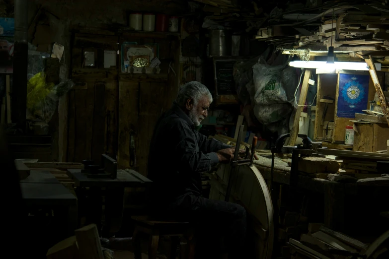 an older man sitting in a room with a lot of wood