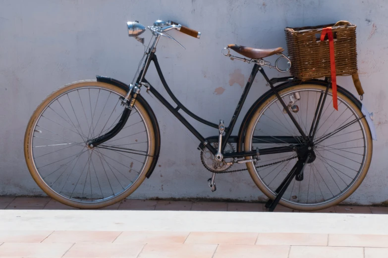 the bicycle is locked against the wall with red ribbon