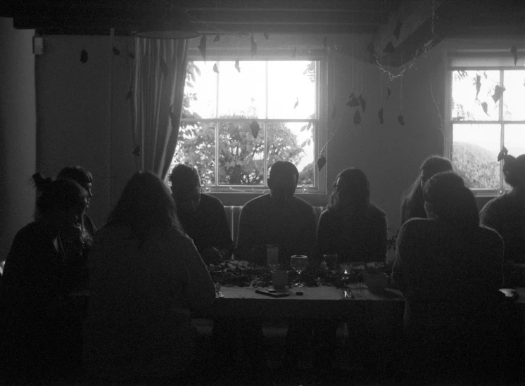 a group of people sitting at a table with food