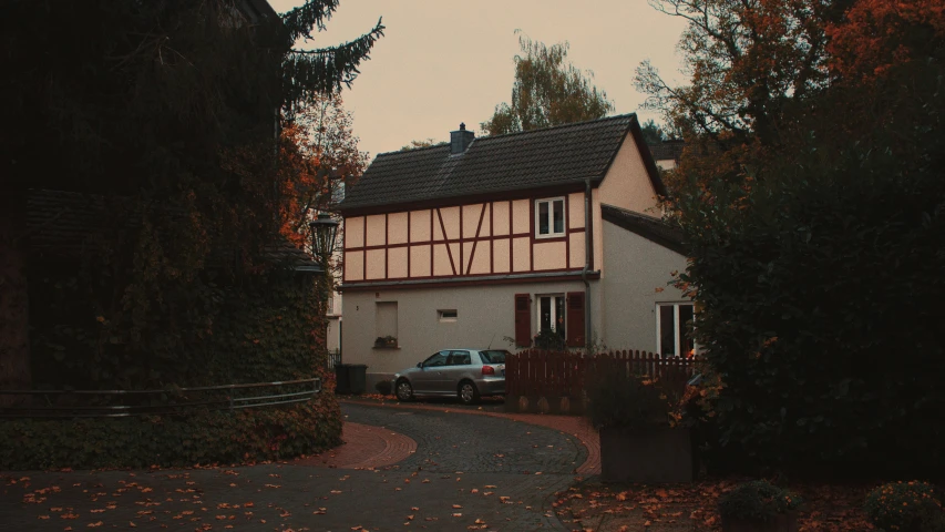 a house sits next to a tree in the autumn