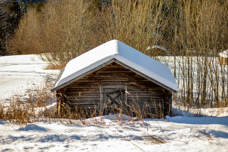 a shack in the snow with a lot of snow on it