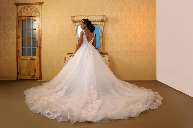 woman in wedding dress standing by mirror inside room