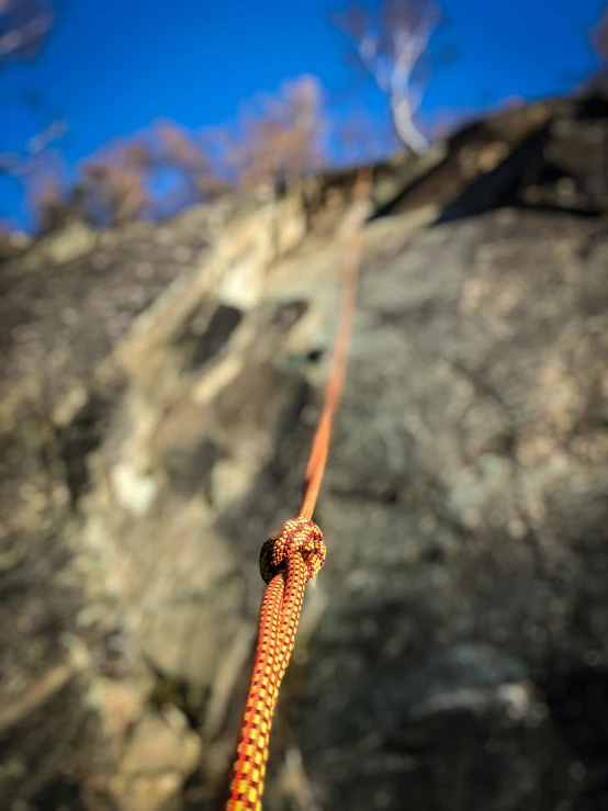 a long rope is suspended from the side of a cliff