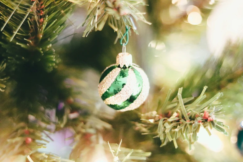 green and white ornament hanging from a christmas tree