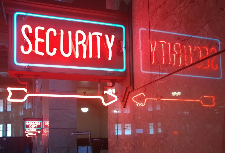 two signs sitting in front of an indoor store with neon lights