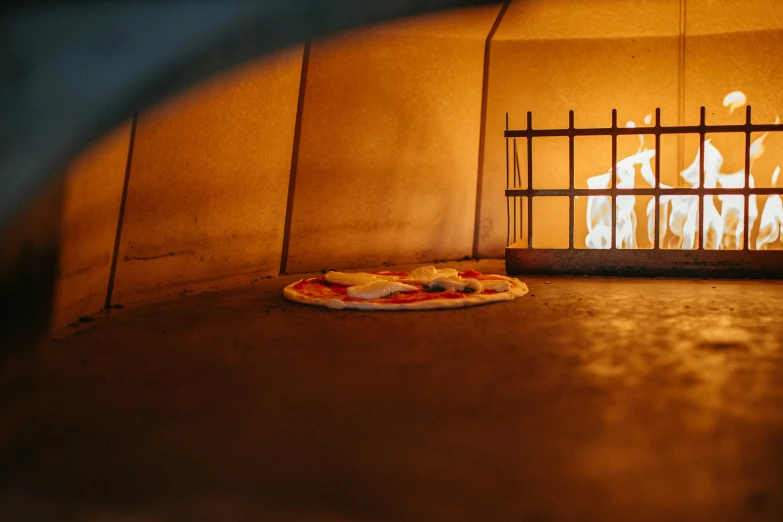 a pizza sitting on a wooden table in front of a fire