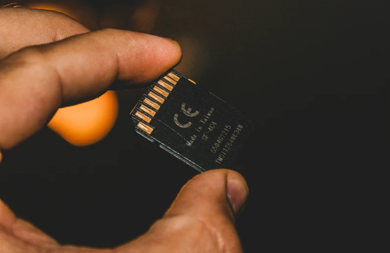 a hand is holding a business card with one finger