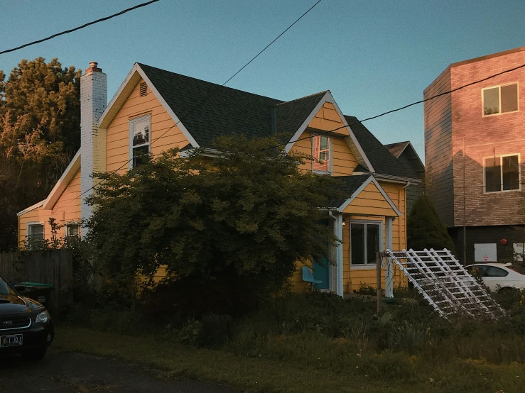 a black car parked next to a large yellow house